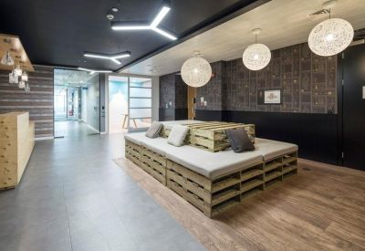 Modern lounge area with wooden pallet seating, orb pendant lights, and dark feature walls.
