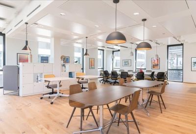 Spacious communal breakout area with diverse seating options and modern spherical pendant lighting.