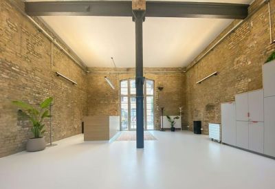 Large reception area featuring a central steel pillar and exposed brick walls.