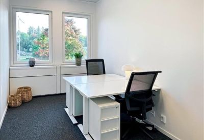 Private two-person office suite with white desks and black ergonomic chairs.