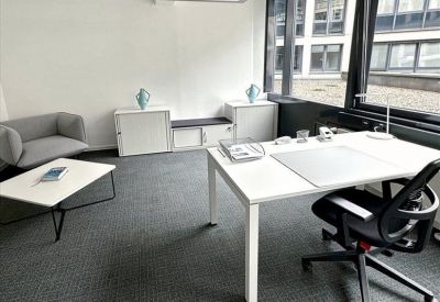 Communal kitchen and breakout area with white cabinetry and pendant lighting.