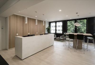 Minimalist reception area featuring a long white desk and wood-slat wall.