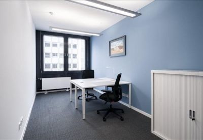 Small private office with two desks, ergonomic chairs, and a large window.