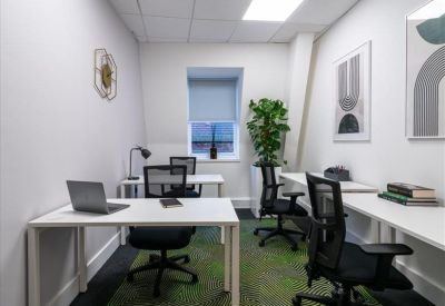 Private four-desk office suite with white workstations and ergonomic mesh chairs.