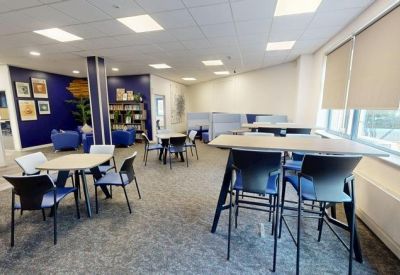 Bright breakout area with cafe-style seating and high-top tables.