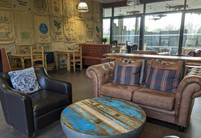 Industrial style cafe area with coffee sack wall hangings and leather sofas.
