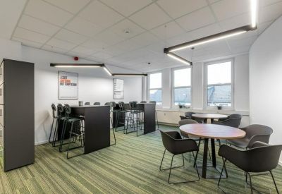 Breakout area with high-top tables, bar stools, and modern linear pendant lighting.
