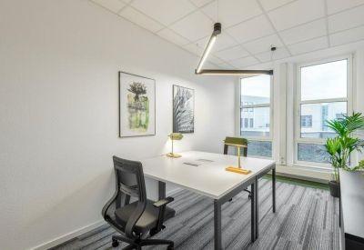 Private office suite featuring a two-person white desk, ergonomic chairs, and large windows.