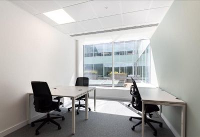Private office with white desks and black ergonomic chairs near a large window.