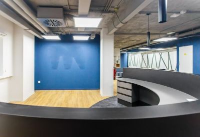 Modern reception desk with a curved black counter and a blue feature wall.