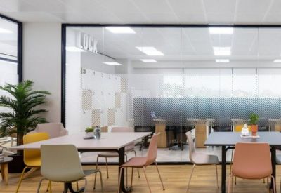 Bright coworking area with colorful chairs and large glass partitions.