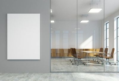 Glass-walled meeting room with a long table, brown leather chairs, and grey accents.
