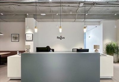 Modern reception area with a minimalist grey desk and pendant lighting.