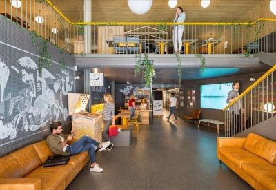 Spacious lounge area with leather sofas and a large blackboard wall.