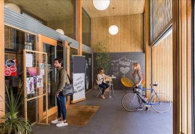 Bright entrance area with wooden walls, plants, and bicycle storage.