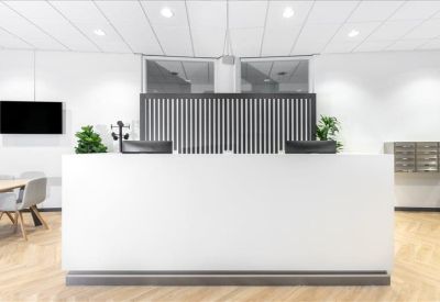 Minimalist white reception desk with wood-style flooring.