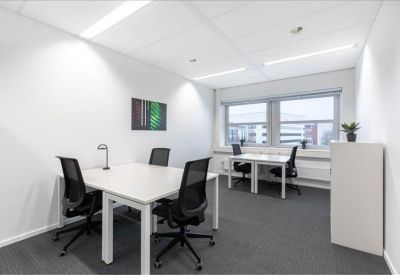 Bright private office with white desks and black mesh chairs.