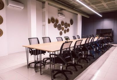 Long boardroom table with mesh chairs and decorative wall art.
