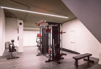 Private gym facility with weight machines and a rowing machine.