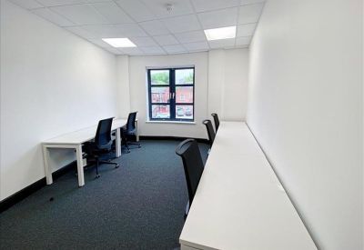 Private office featuring white desks and large windows for natural light.