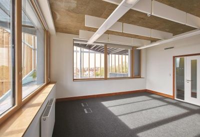 Bright, empty office suite with large windows and wooden accents.