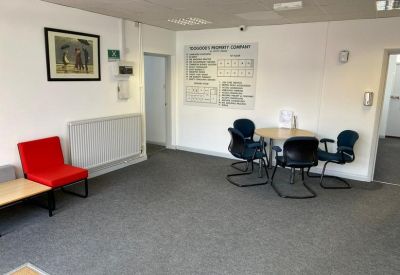 Communal break area with a round table, blue chairs, and a vibrant red accent seat.