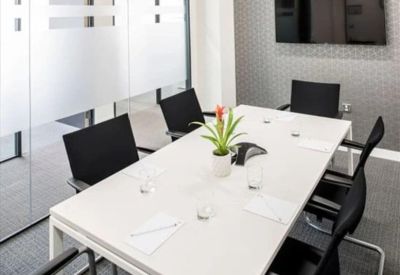 A professional six-person meeting room with a white table and a flat-screen TV.