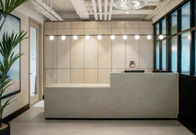 Minimalist reception area featuring a light stone desk and warm pendant lighting.