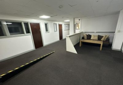 Communal breakout area featuring a sofa with cushions, a coffee table, and a ramped hallway.
