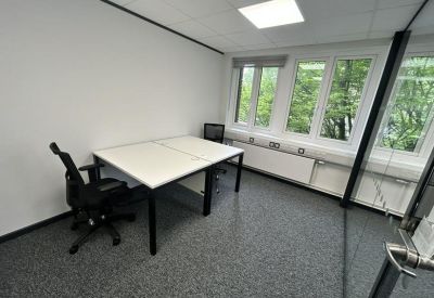 Private two-person office suite with white desks and black mesh chairs.