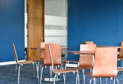 Bright communal breakout area with wooden chairs and blue feature walls.