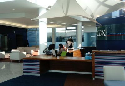 Professional reception area with a long wooden desk and a modern white canopy ceiling.