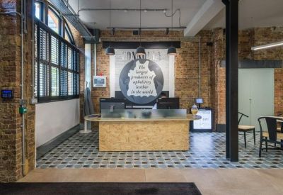Reception area with timber front desk, tiled flooring, and exposed brick walls.