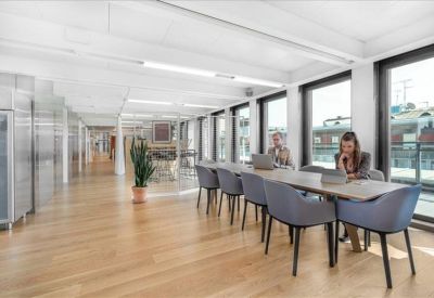 Minimalist conference room featuring a long white table and modern ergonomic chairs.