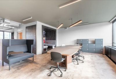 Collaborative workspace with a large communal table, acoustic seating, and modern locker storage.