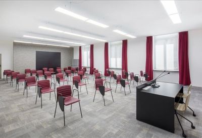 Spacious training room with burgundy chairs and a large presentation screen.