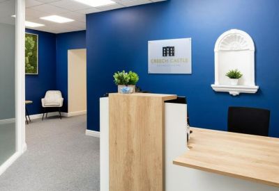 Branded reception area featuring a blue feature wall and light wood desk.