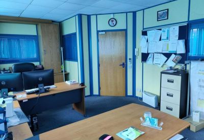Spacious office suite with multiple workstations and a notice board.