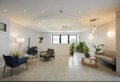 Welcoming reception lobby with plush seating, warm lighting, and leafy green plants.