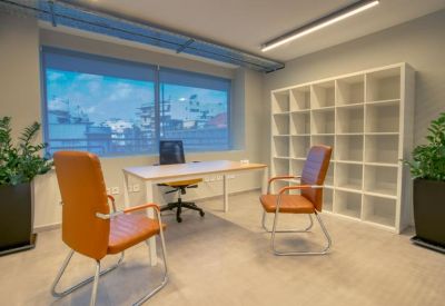Private office suite featuring orange leather chairs and a white bookshelf.