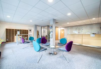 Modern breakout area with colourful teal and purple seating around a glass coffee table.