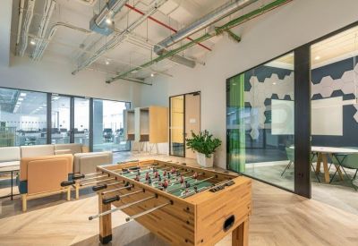 Lounge area featuring a foosball table, modern armchairs, and wood-paneled accents.