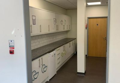 Long galley kitchen with white cabinets and illustrated decals.