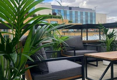 Rooftop terrace at Duke House, 33 Duke Street, London featuring lounge chairs and lush greenery.
