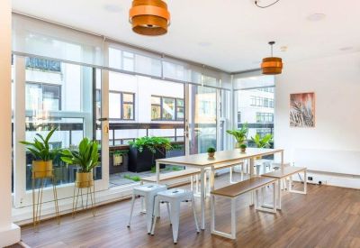 Bright dining area with wooden pendant lights, long tables, and large windows.