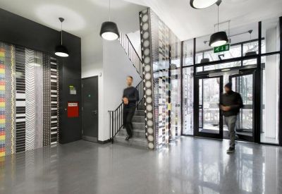 Lobby area featuring a patterned feature wall, staircase, and glass entrance doors.