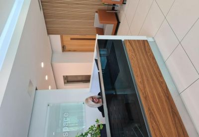 Reception desk with wood paneling and a visitor lounge area.