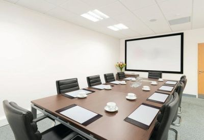 Conference room featuring a large projection screen and a long wooden table.