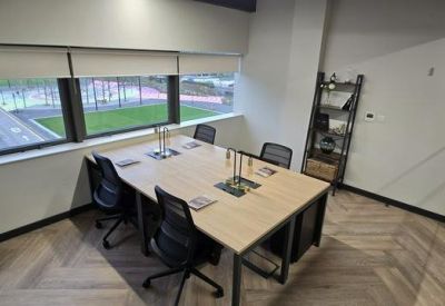 Private office suite with a four-person desk and large window view.