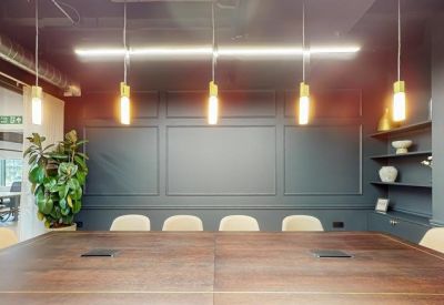 Professional boardroom with a dark feature wall and modern pendant lighting.